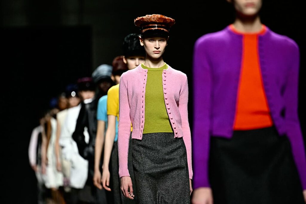 Modelle in passerella con twin set e maglie colorate in viola, verde e arancio